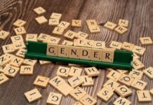Ograniczenia tranzycji płciowej młodzieży nie zwiększają ryzyka samobójstw Klocki Scrabble układające słowo GENDER wśród rozsypanych liter na drewnianym stole, symbol debaty o tranzycji płciowej młodzieży