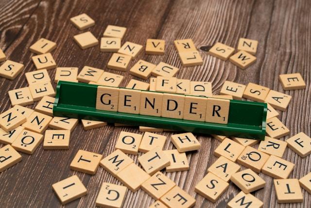 markus-winkler-y6UhsOWDiVs-unsplash-1 Klocki Scrabble układające słowo GENDER wśród rozsypanych liter na drewnianym stole, symbol debaty o tranzycji płciowej młodzieży