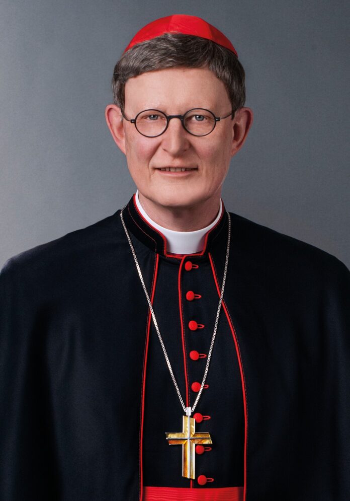 Kardynał Rainer Maria Woelki w czerwonej piusce i czarnej sutannie z pektorałem, oficjalny portret arcybiskupa Kolonii