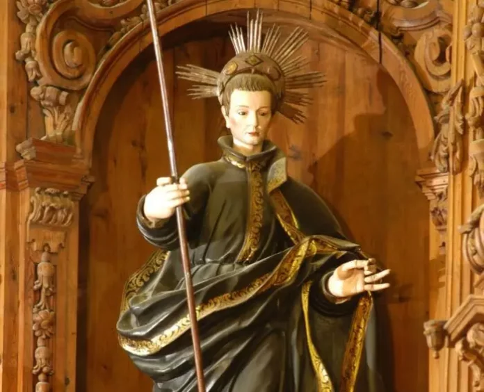 4-2-700x567-1 Figura świętego Jana Berchmansa w czarnej jezuickiej sutannie ze złoceniami, z aureolą promieni wokół głowy, trzymającego laskę, w rzeźbionej niszy