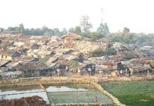 Mniejszości w Bangladeszu celem ataków – raport o 257 incydentach Obóz uchodźców Kutupalong w Bangladeszu: chaty o dachach z trzciny i plandek gęsto zabudowane na zboczu wzgórza, z zalanymi polami ryżowymi na pierwszym planie.