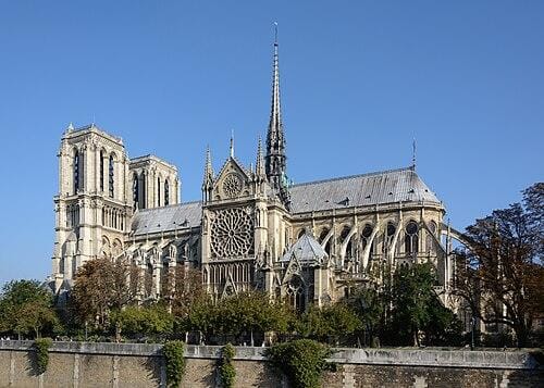 500px-Paris_Notre-Dame_South_View_03 Katedra Notre-Dame w Paryżu widziana od strony południowej: gotycka bryła z iglicą, rozetą i przyporami na tle bezchmurnego nieba