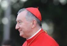 Kard. Parolin zamyka jubileusz św. Agaty w Katanii, 900 lat po powrocie relikwii Kard. Pietro Parolin w czerwonym stroju chórowym i piusce, ujęty z profilu podczas uroczystości na wolnym powietrzu w Rzymie