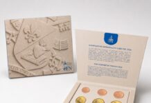 Watykan przywraca wizerunek papieża na monetach euro za pontyfikatu Leona XIV Otwarty kremowy folder z watykańskim zestawem ośmiu monet euro 2026; tłoczony herb papieża Leona XIV z lilią, gorejącym sercem i otwartą księgą.