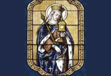 Św. Radegunda: branka, królowa Franków i założycielka wspólnoty zakonnej Witraż przedstawiający św. Radegundę w koronie i zakonnym welonie, w królewskim płaszczu z motywem lilii, trzymającą berło i złoty relikwiarz