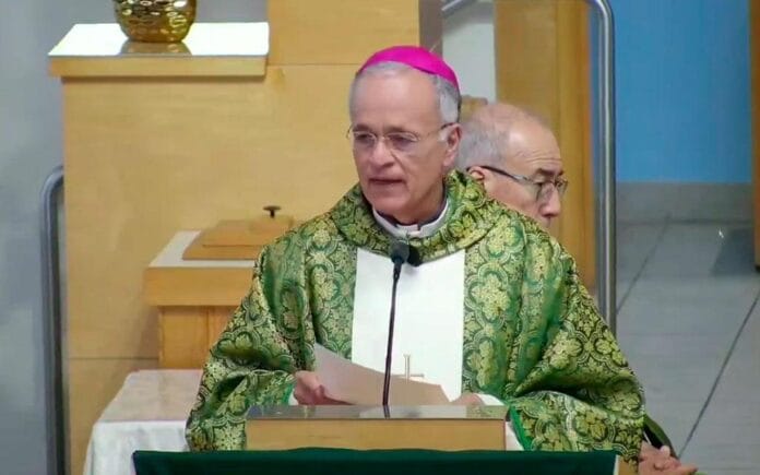 Silvio-Baez-St-Agatha-Catholic-Parrish-10082026_kyewg2 Bp Silvio Báez w fioletowej piusce i zielonym ornacie czyta homilię przy ambonie; za nim drugi duchowny we wnętrzu kościoła
