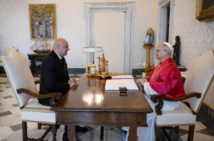 cq5dam.thumbnail.cropped.1500.844-2 Papież Leon XIV w czerwonej mucecie rozmawia przy biurku z prezydentem Libanu Josephem Aounem w ciemnym garniturze, w Pałacu Apostolskim