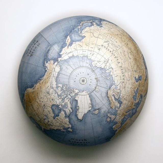 gael-gaborel-orbisterrae-f7I8uEiYkag-unsplash Globus przedstawiający półkulę północną z niebieskimi oceanami i różą wiatrów na biegunie północnym