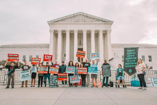 maria-oswalt-JjX7BZ-Cll8-unsplash-1 Grupa demonstrantów z tabliczkami przeciw karze śmierci stoi przed gmachem Sądu Najwyższego USA w Waszyngtonie