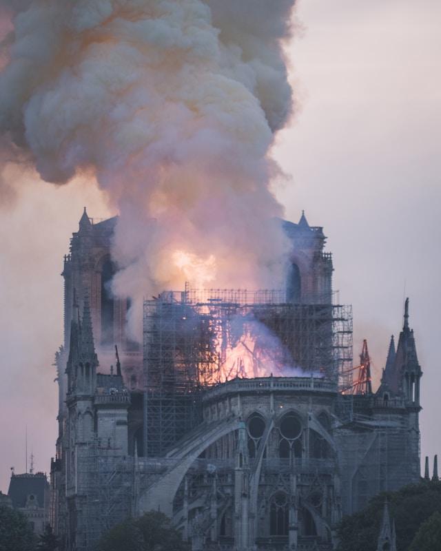 nivenn-lanos-MSA6bPCmyms-unsplash Katedra Notre-Dame w Paryżu w płomieniach — kłęby dymu unoszą się nad gotycką świątynią otoczoną rusztowaniami podczas pożaru