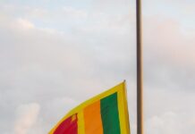 Sri Lanka: duchowieństwo domaga się międzynarodowego śledztwa w Chemmani Flaga narodowa Sri Lanki powiewa na maszcie nad złotym posągiem lwa, przy którym stoją dwaj umundurowani wartownicy