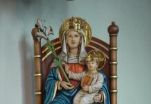 Rekordowa frekwencja na pielgrzymce Latin Mass Society z Ely do Walsingham Polichromowana figura Matki Bożej z Walsingham: ukoronowana Maryja na drewnianym tronie trzyma lilię i ukoronowane Dzieciątko Jezus z księgą.