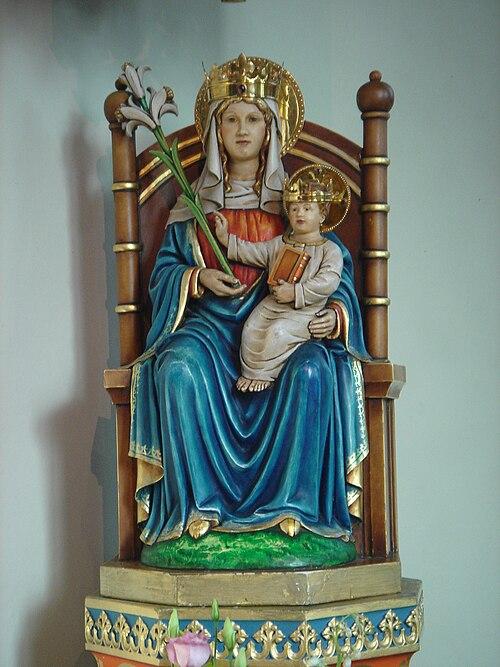 500px-Our_Lady_of_Walsingham Polichromowana figura Matki Bożej z Walsingham: ukoronowana Maryja na drewnianym tronie trzyma lilię i ukoronowane Dzieciątko Jezus z księgą.