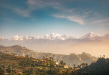 Powódź w Nepalu: tysiące zabitych lub zaginionych po katastrofie w Himalajach Ośnieżone szczyty Himalajów nad tarasowymi wzgórzami i domami w wiejskim Nepalu; zdjęcie ilustracyjne, nie przedstawia terenów dotkniętych powodzią