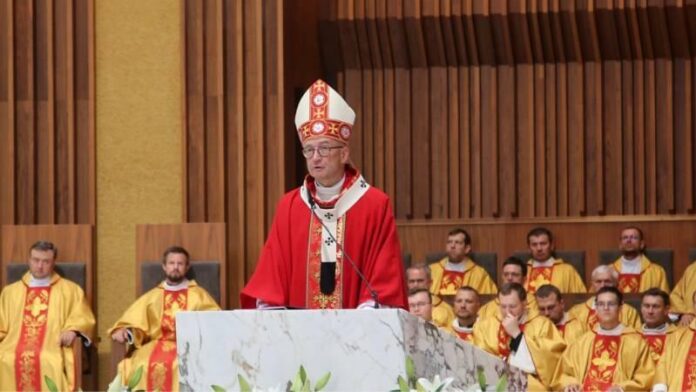 adrian-galbas Abp Adrian Galbas w mitrze i czerwonym ornacie głosi homilię z marmurowej ambony, za nim rzędy koncelebrujących kapłanów w złotych ornatach