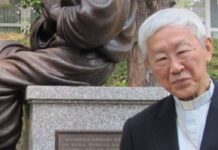 Hongkong: oddalona apelacja kard. Josepha Zena i powierników Funduszu 612 Kard. Joseph Zen w czarnym stroju duchownego z koloratką przy brązowym pomniku na granitowym cokole z chińską inskrypcją — zdjęcie archiwalne.