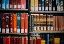 Dzień Biblii w Chía unieważniony: kolumbijski sąd powołuje się na neutralność państwa Regały biblioteczne wypełnione komentarzami do Ewangelii św. Jana i księgami teologicznymi w czerwonych, brązowych i niebieskich oprawach