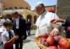 Castel Gandolfo świętuje 400 lat obecności papieży i troski o wspólnotę Papież w bieli przyjmuje kosz brzoskwiń od mieszkańców na placu w Castel Gandolfo; obok dzieci w strojach ludowych, urzędnik miejski i biskup w fiolecie.