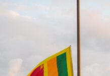 Sri Lanka: kard. Ranjith wzywa rybaków, by odrzucili przemyt narkotyków Flaga Sri Lanki rozwinięta na maszcie, przed nią złocony posąg lwa, obok dwaj wartownicy w ciemnych mundurach — zdjęcie ilustracyjne