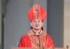 Nowy biskup w Chinach wyświęcony w ramach porozumienia Watykan–Pekin Młody biskup w czerwonej mitrze i czerwono-złotym ornacie stoi przy ambonie z mikrofonem w jasnym wnętrzu kościoła