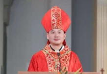 Nowy biskup w Chinach wyświęcony w ramach porozumienia Watykan–Pekin Młody biskup w czerwonej mitrze i czerwono-złotym ornacie stoi przy ambonie z mikrofonem w jasnym wnętrzu kościoła
