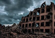Papież prosi Putina o rozejm humanitarny w Ołeszkach. Watykan nasila apele o pomoc i pokój Zniszczony, częściowo zawalony wielopiętrowy budynek i sterty gruzu pod ciemnym, burzowym niebem – zdjęcie ilustracyjne